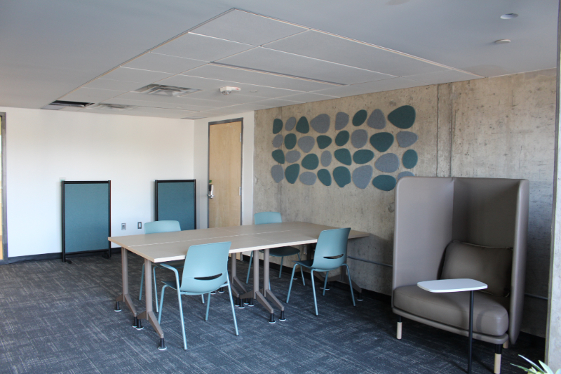 The Low Sensory Space located in Rideau House. A decent sized room with tables, chairs, and a tiled design on the wall.