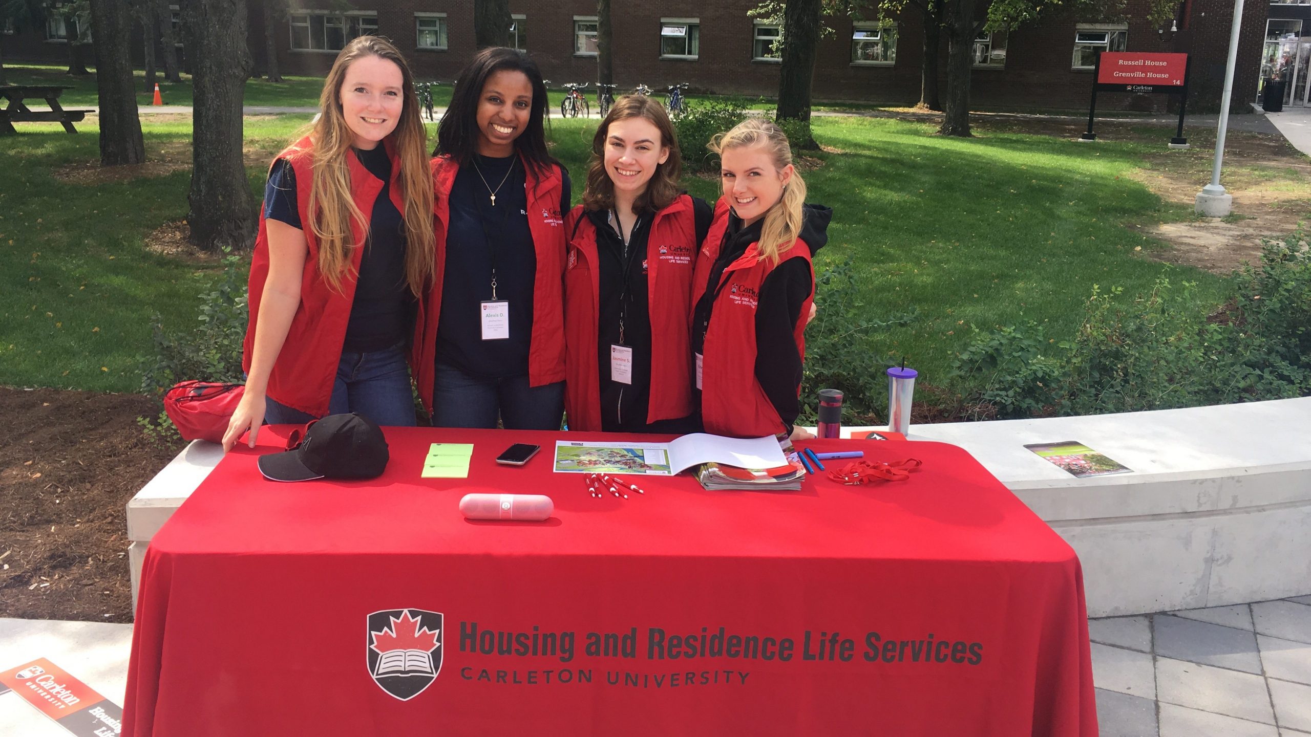 Four residence staff pose for a photo behind a desk