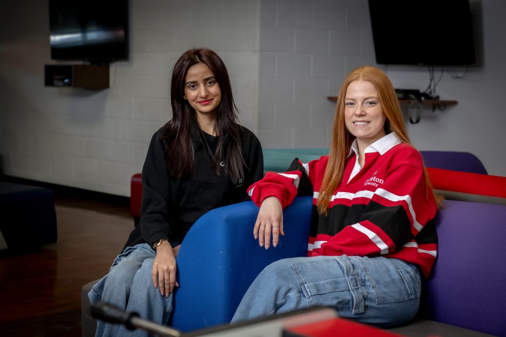 Two Carleton students seated in Raven's Roost.